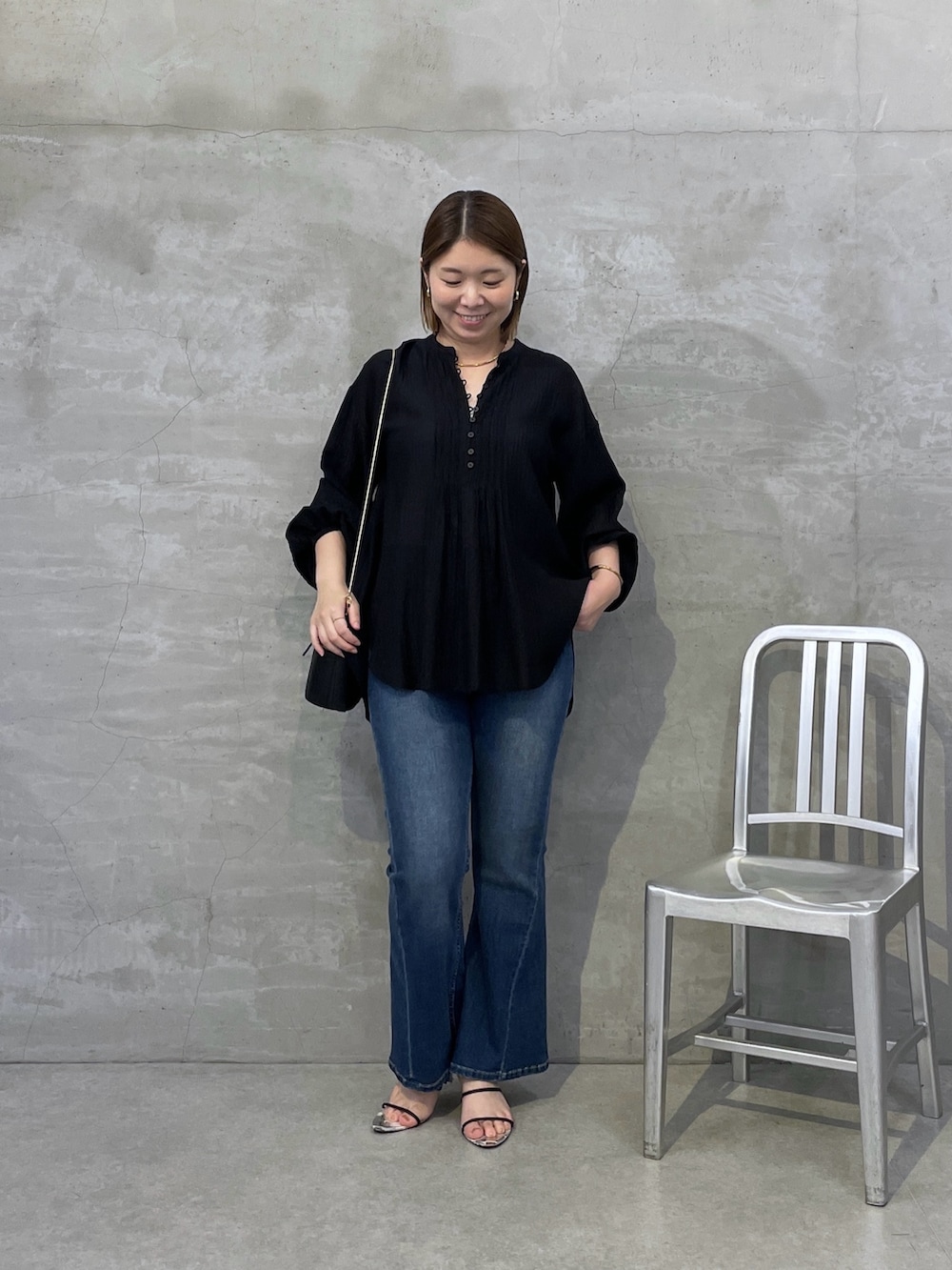 ブルー系のデニムパンツ、ブラック系のシャツ/ブラウス、ブラック系のショルダーバッグを着用したレディースの夏コーディネートの5枚目の写真
