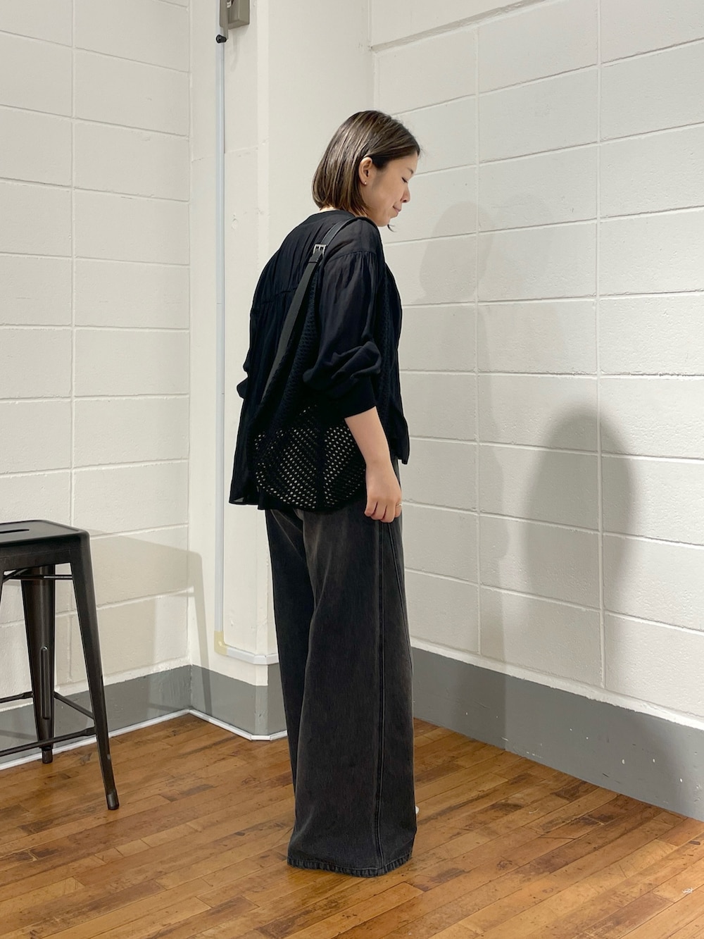 ブラック系のデニムパンツ、ブラック系のシャツ/ブラウス、ブラック系のショルダーバッグを着用したレディースの夏コーディネートの2枚目の写真