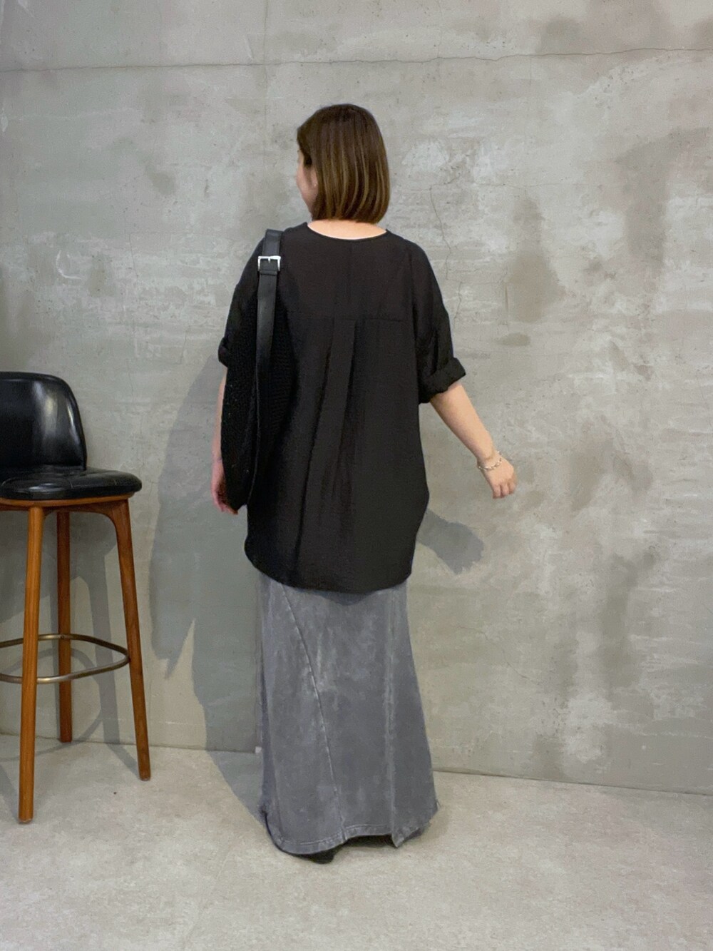 ブラック系のシャツ/ブラウス、グレー系のスカート、ブラック系のショルダーバッグを着用したレディースの夏コーディネートの3枚目の写真