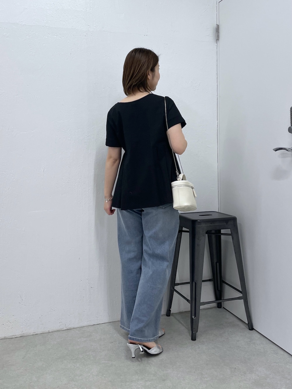 ブラック系のシャツ/ブラウス、ブルー系のデニムパンツ、ホワイト系のショルダーバッグを着用したレディースの春コーディネートの3枚目の写真