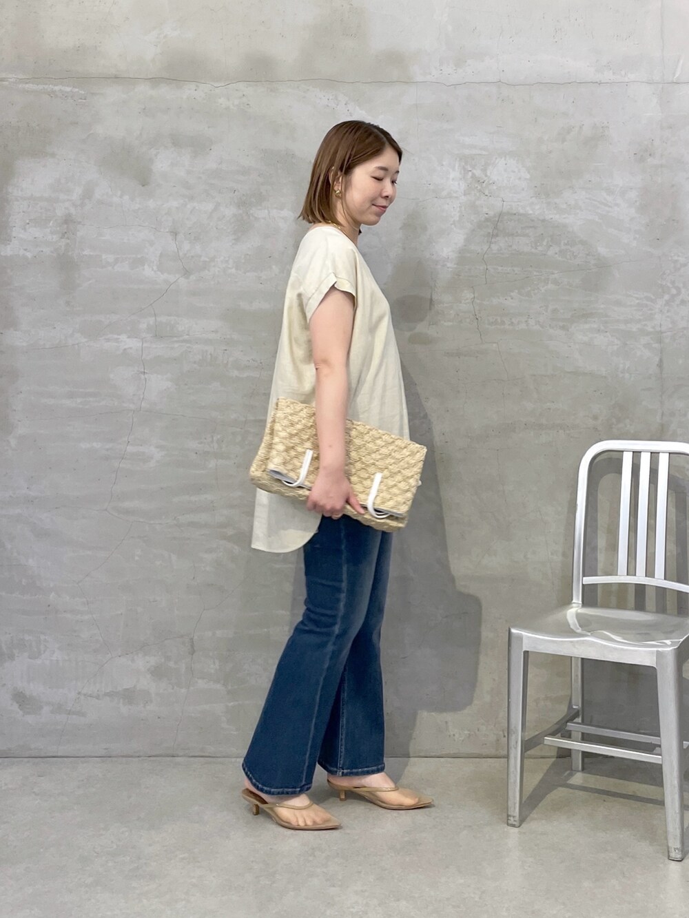 ベージュ系のシャツ/ブラウス、ブルー系のデニムパンツ、ホワイト系のトートバッグを着用したレディースの夏コーディネートの2枚目の写真