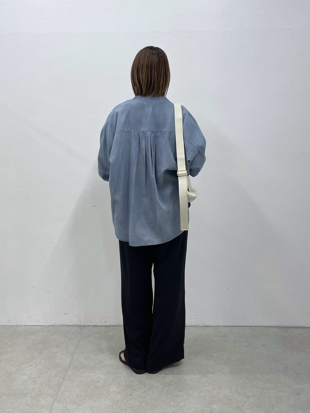 ブルー系のシャツ/ブラウス、ブラック系のつなぎ/オールインワン、ホワイト系のショルダーバッグを着用したレディースの春コーディネートの3枚目の写真