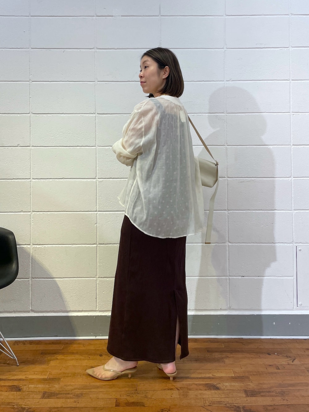 ブラウン系のワンピース、ホワイト系のシャツ/ブラウス、ホワイト系のショルダーバッグを着用したレディースの夏コーディネートの2枚目の写真