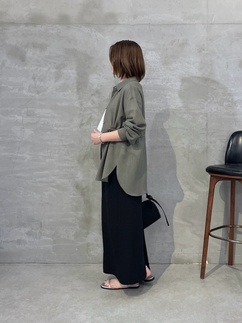 グリーン系のシャツ/ブラウス、ホワイト系のTシャツ/カットソー、ブラック系のスカートを着用したレディースの春コーディネートの2枚目の写真