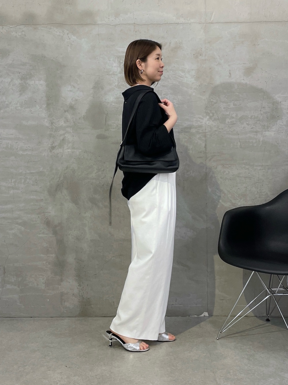 ブラック系のシャツ/ブラウス、ホワイト系のスラックス、ブラック系のショルダーバッグを着用したレディースの冬コーディネートの2枚目の写真