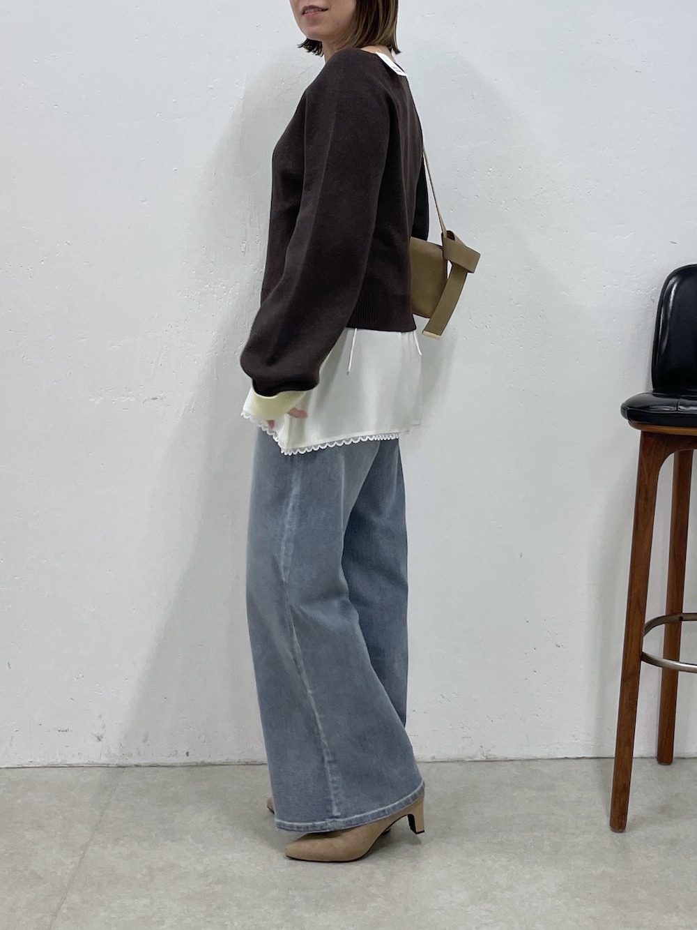 ブラウン系のニット/セーター、ホワイト系のキャミソール、ブルー系のデニムパンツを着用したレディースの秋コーディネートの2枚目の写真