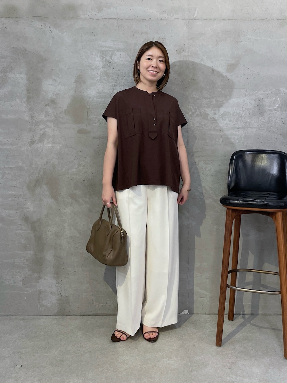 ブラウン系のTシャツ/カットソー、ホワイト系のスラックス、ブラウン系のボストンバッグを着用したレディースの夏コーディネートの5枚目の写真