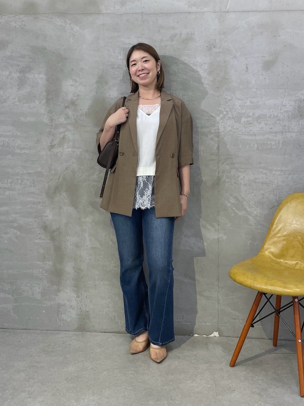 ブラウン系のテーラードジャケット、ホワイト系のTシャツ/カットソー、ブルー系のデニムパンツを着用したレディースの夏コーディネートの4枚目の写真