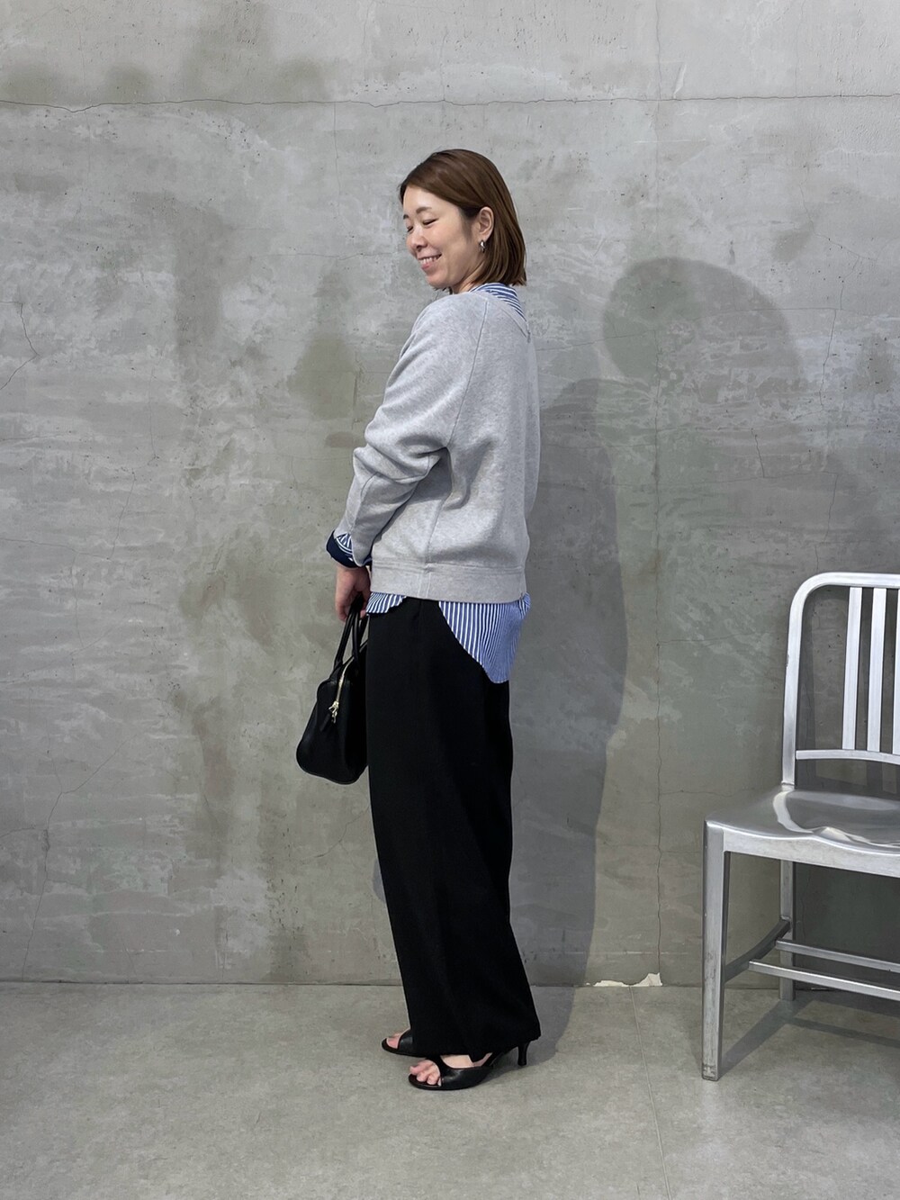 ブルー系のシャツ/ブラウス、ブラック系のその他パンツ、グレー系のニット/セーターを着用したレディースの夏コーディネートの2枚目の写真