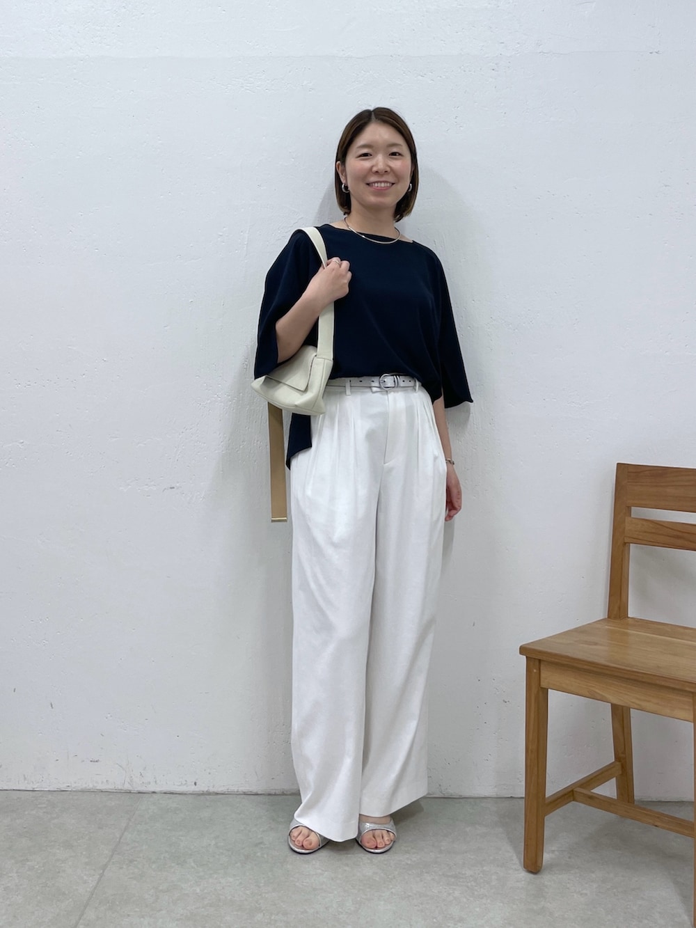 ブルー系のシャツ/ブラウス、ホワイト系のスラックス、ホワイト系のショルダーバッグを着用したレディースの春コーディネートの5枚目の写真