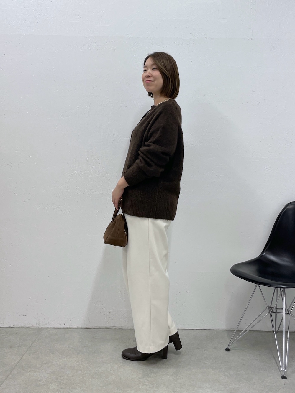 ブラウン系のニット/セーター、ホワイト系のその他パンツ、ブラウン系のボストンバッグを着用したレディースの冬コーディネートの2枚目の写真