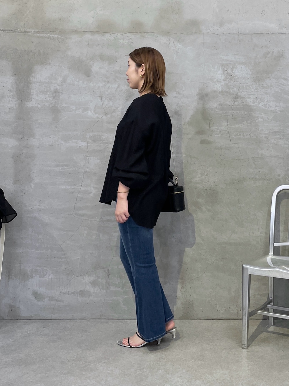 ブルー系のデニムパンツ、ブラック系のシャツ/ブラウス、ブラック系のショルダーバッグを着用したレディースの夏コーディネートの2枚目の写真