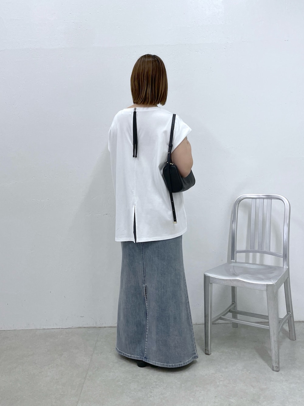 ホワイト系のTシャツ/カットソー、ブルー系のスカート、ブラック系のショルダーバッグを着用したレディースの夏コーディネートの3枚目の写真