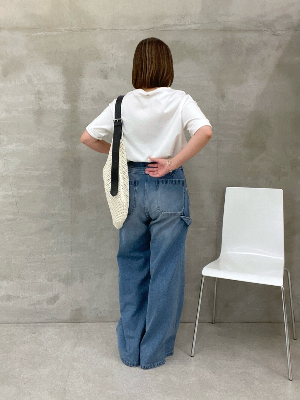 ブルー系のデニムパンツ、ホワイト系のTシャツ/カットソー、ホワイト系のバッグを着用したレディースの夏コーディネートの3枚目の写真