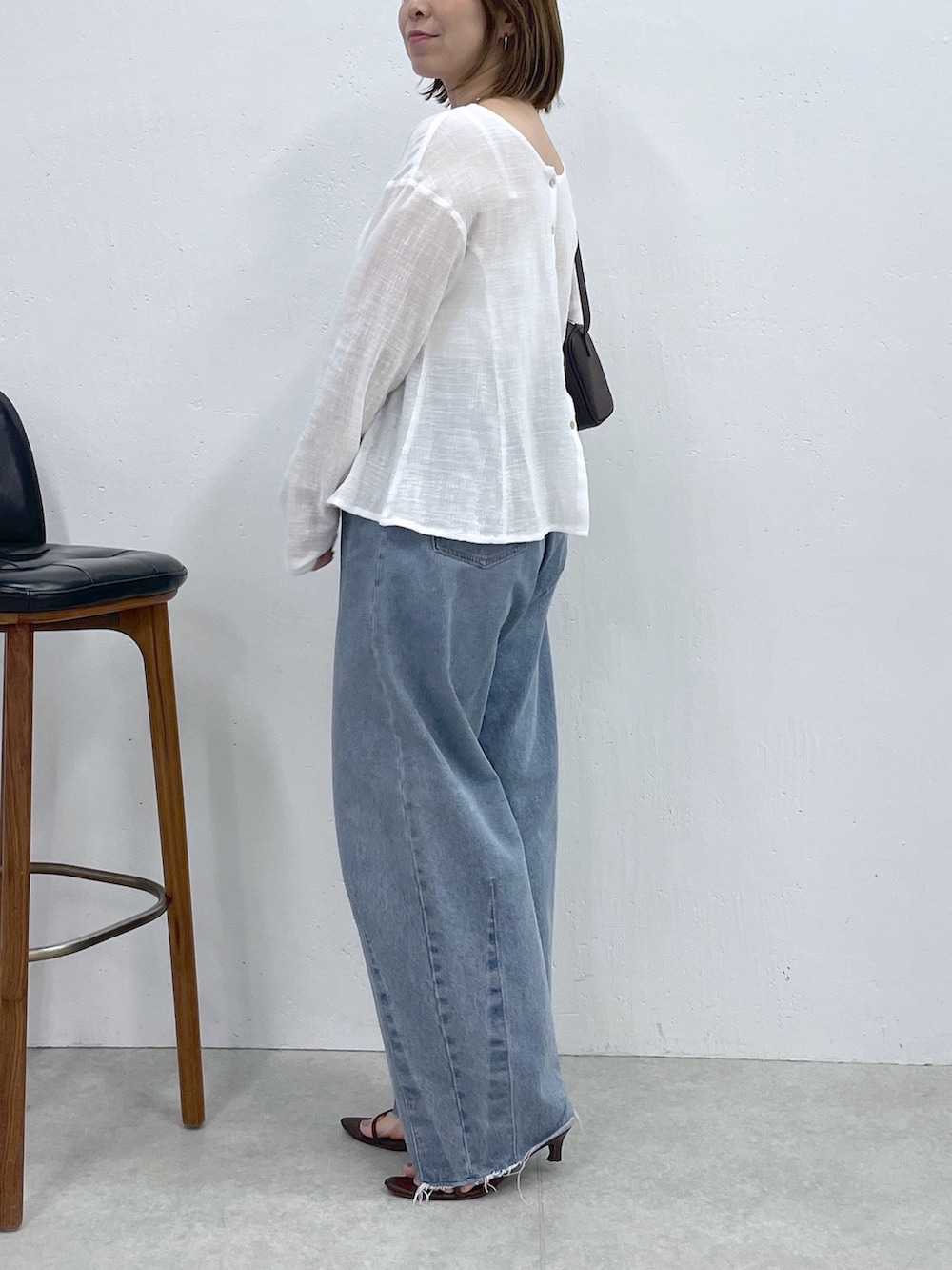 ホワイト系のシャツ/ブラウス、ブルー系のデニムパンツ、ブラック系のショルダーバッグを着用したレディースの夏コーディネートの2枚目の写真