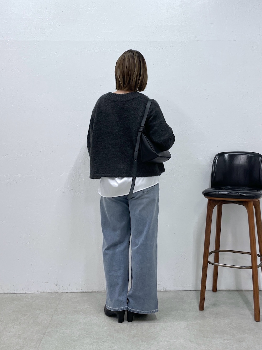 グレー系のカーディガン/ボレロ、ホワイト系のシャツ/ブラウス、ブルー系のデニムパンツを着用したレディースの秋コーディネートの3枚目の写真
