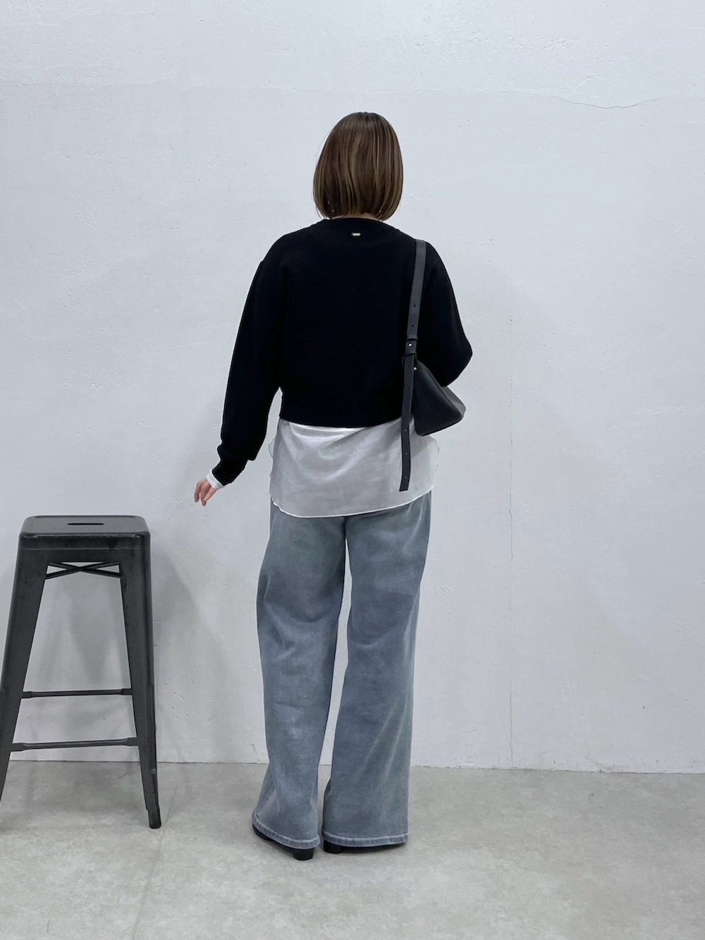 ブラック系のカーディガン/ボレロ、ホワイト系のTシャツ/カットソー、ブルー系のデニムパンツを着用したレディースの冬コーディネートの3枚目の写真