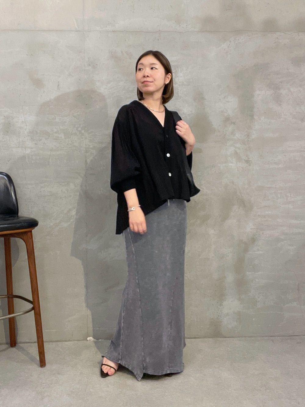 グレー系のスカート、ブラック系のシャツ/ブラウス、ブラック系のバッグを着用したレディースの夏コーディネートの2枚目の写真