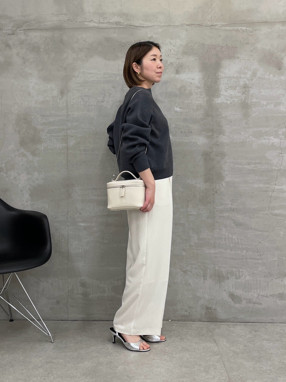 グレー系のニット/セーター、ホワイト系のスラックス、ホワイト系のショルダーバッグを着用したレディースの冬コーディネートの2枚目の写真