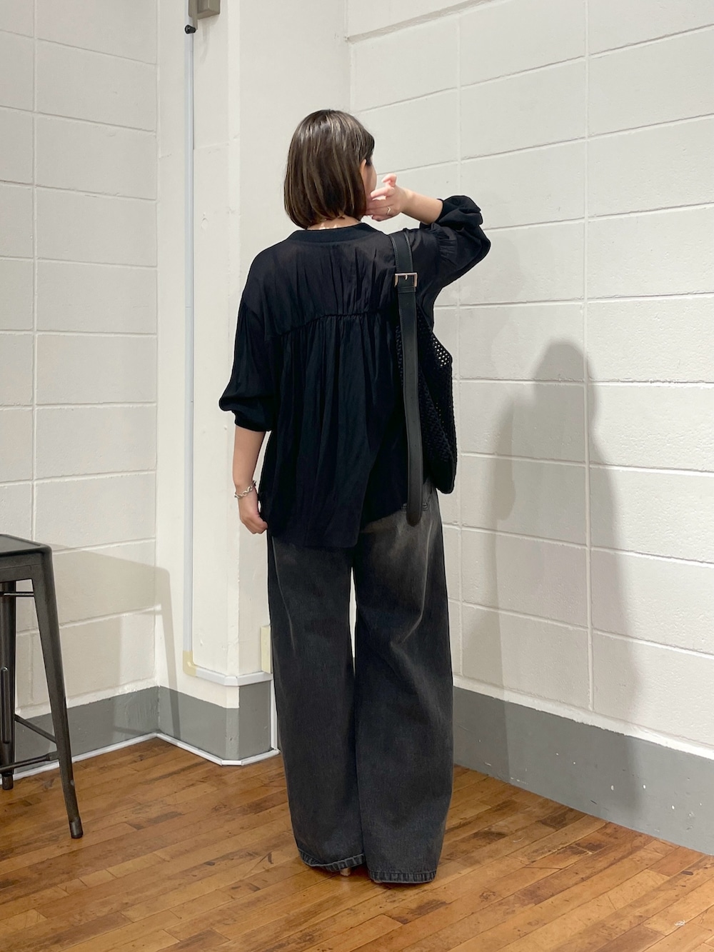 ブラック系のデニムパンツ、ブラック系のシャツ/ブラウス、ブラック系のショルダーバッグを着用したレディースの夏コーディネートの3枚目の写真