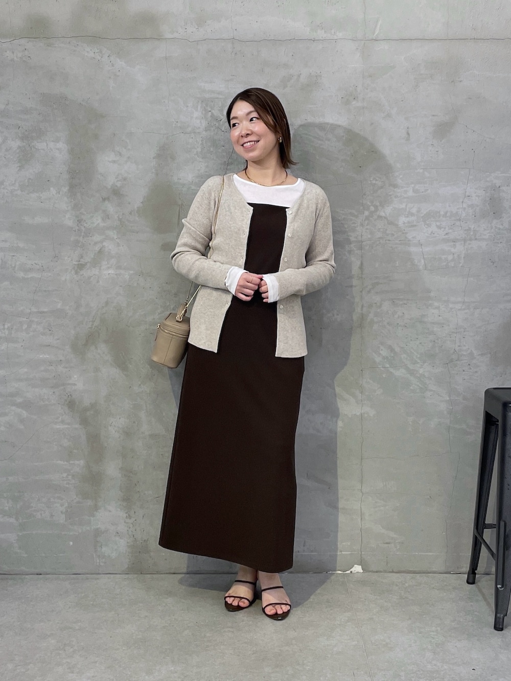 ベージュ系のカーディガン/ボレロ、ブラウン系のワンピース、ホワイト系のTシャツ/カットソーを着用したレディースの春コーディネートの4枚目の写真