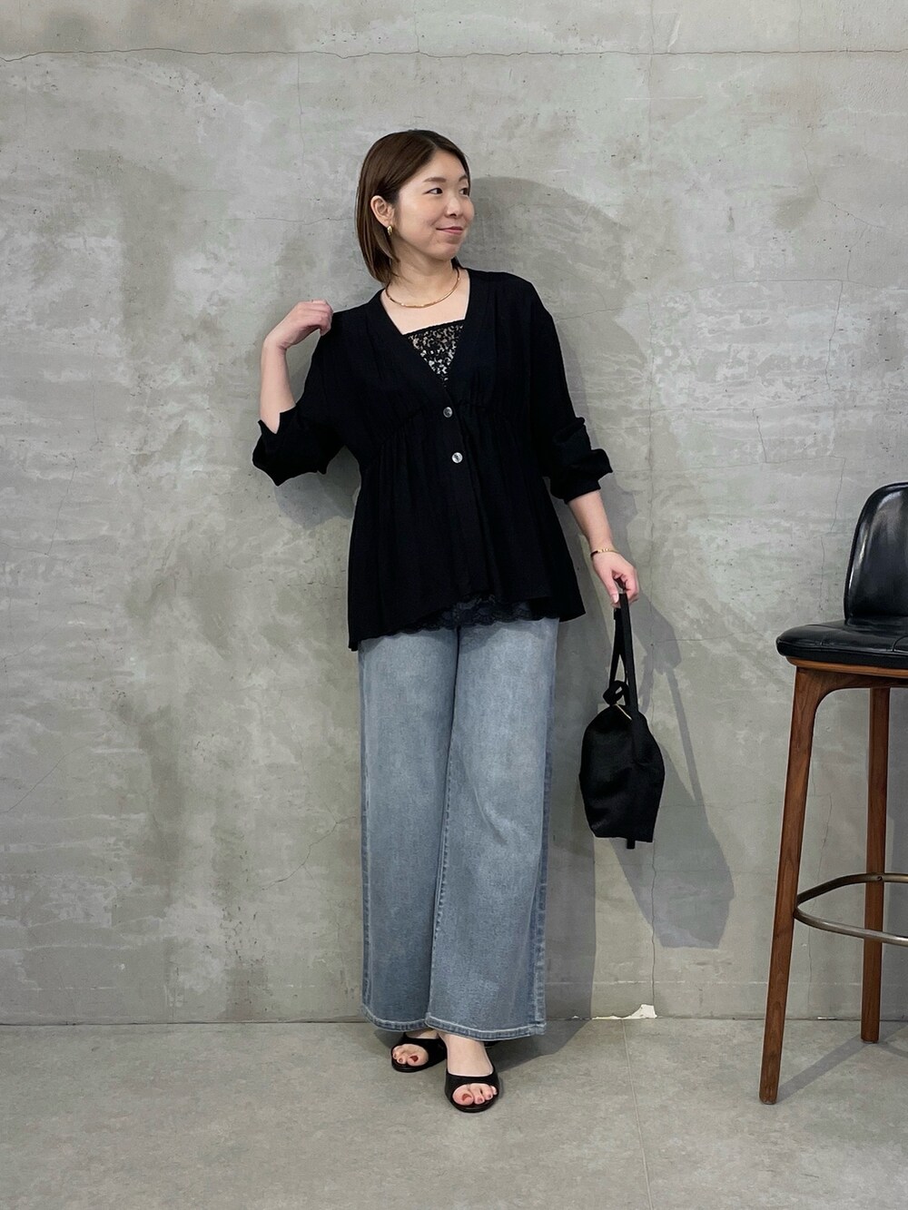 ブラック系のシャツ/ブラウス、ブラック系のキャミソール、ブルー系のデニムパンツを着用したレディースの春コーディネートの5枚目の写真
