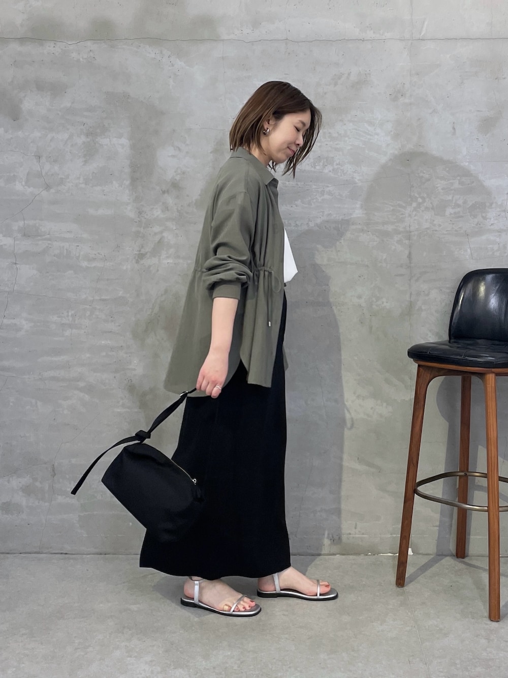 グリーン系のシャツ/ブラウス、ホワイト系のTシャツ/カットソー、ブラック系のスカートを着用したレディースの春コーディネートの4枚目の写真