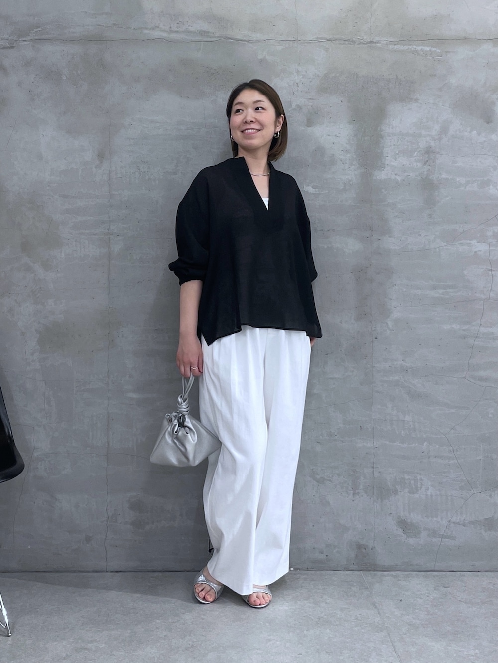 ブラック系のシャツ/ブラウス、ホワイト系のスラックスを着用したレディースの春コーディネートの5枚目の写真