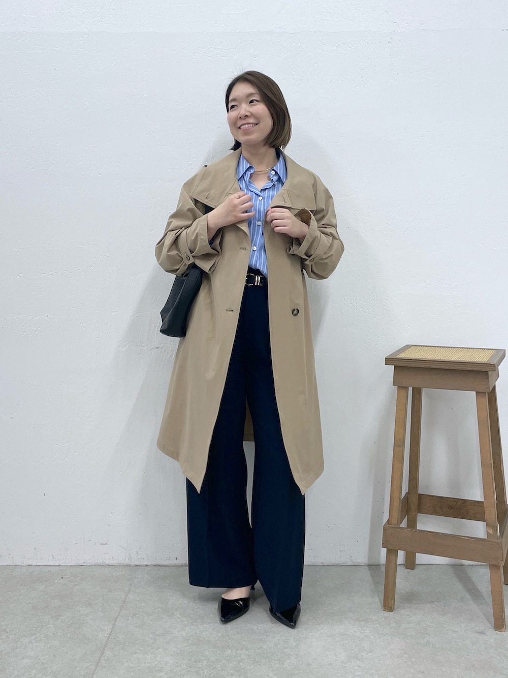 ベージュ系のその他アウター、ブルー系のシャツ/ブラウス、ブルー系のスラックスを着用したレディースの冬コーディネートの5枚目の写真