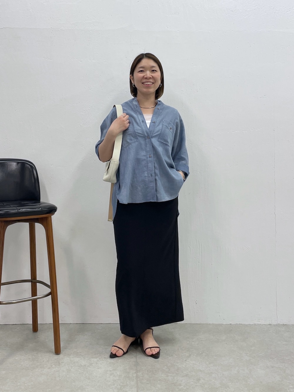 ブルー系のシャツ/ブラウス、ホワイト系のタンクトップ、ブラック系のスカートを着用したレディースの春コーディネートの4枚目の写真