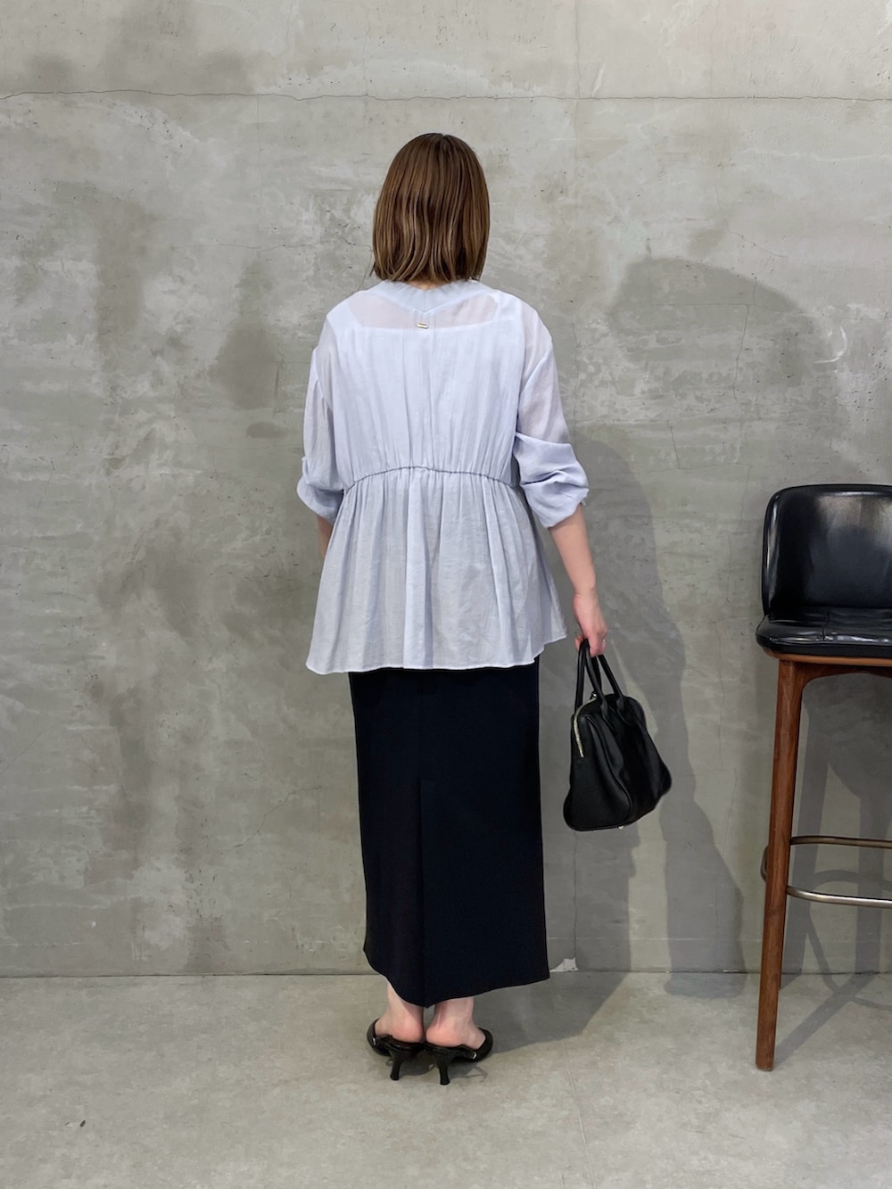ブルー系のシャツ/ブラウス、ブラック系のスカート、ブラック系のボストンバッグを着用したレディースの夏コーディネートの2枚目の写真