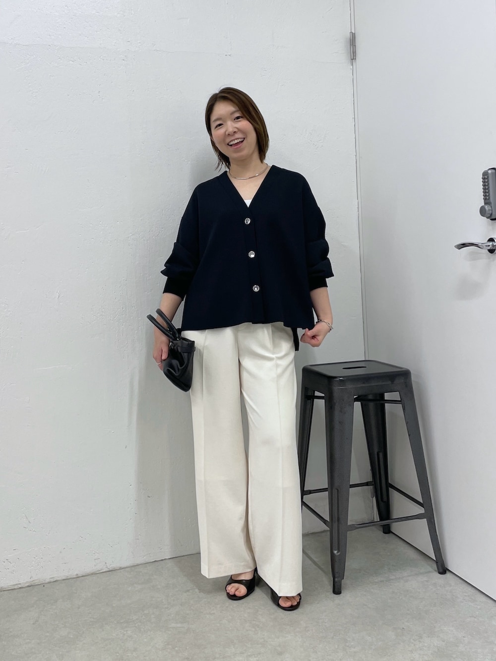 ブルー系のカーディガン/ボレロ、ホワイト系のスラックス、ブラック系のトートバッグを着用したレディースの春コーディネートの4枚目の写真