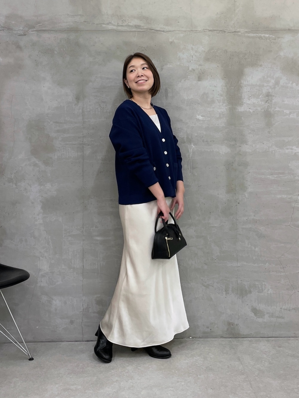 ホワイト系のスカート、ブルー系のカーディガン/ボレロ、ブラック系のボストンバッグを着用したレディースの冬コーディネートの4枚目の写真