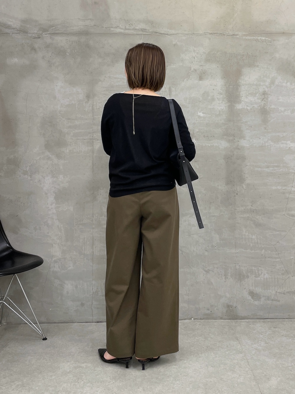 グリーン系のチノパンツ、ブラック系のTシャツ/カットソー、ホワイト系のTシャツ/カットソーを着用したレディースの冬コーディネートの2枚目の写真