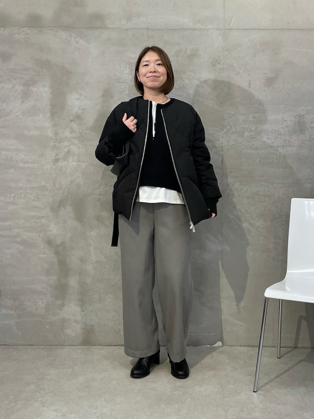 ブラック系のダウンジャケット/コート、グレー系のその他パンツ、ブラック系のニット/セーターを着用したレディースの秋コーディネートの4枚目の写真