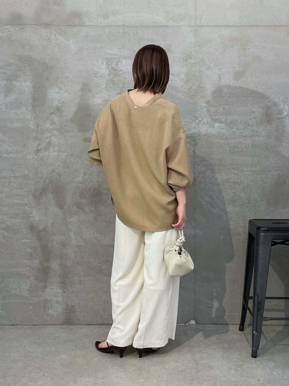 ベージュ系のシャツ/ブラウス、ホワイト系のスラックス、ホワイト系のショルダーバッグを着用したレディースの春コーディネートの3枚目の写真