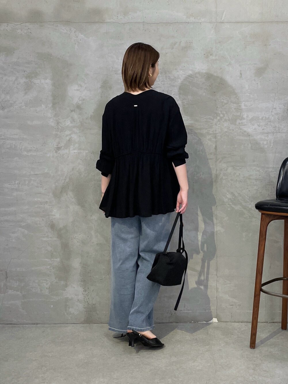 ブラック系のシャツ/ブラウス、ブラック系のキャミソール、ブルー系のデニムパンツを着用したレディースの春コーディネートの3枚目の写真