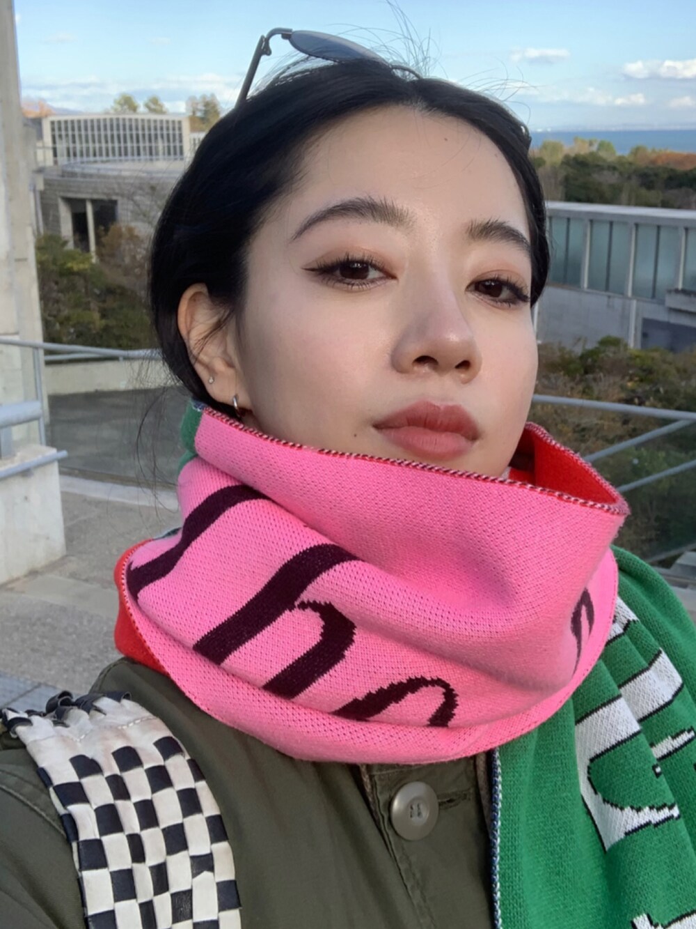 グリーン系のジャケット/アウター、ブラック系のパンツ、ブラック系のスニーカーを着用したレディースの冬コーディネートの2枚目の写真