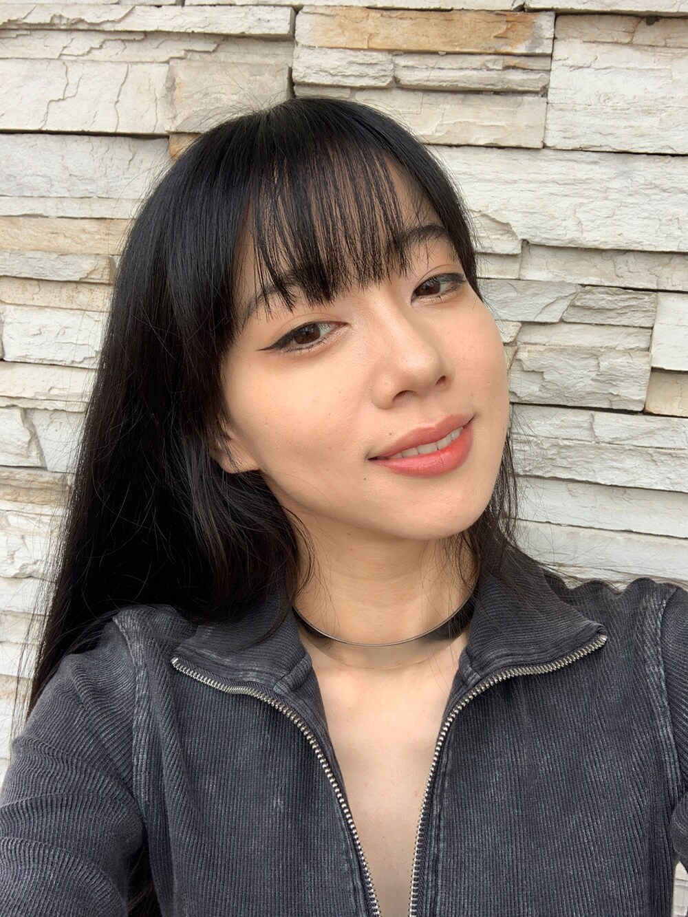 ブラック系のトップス、ブルー系のスカート、ピンク系のアイシャドウを着用したレディースの秋コーディネートの2枚目の写真