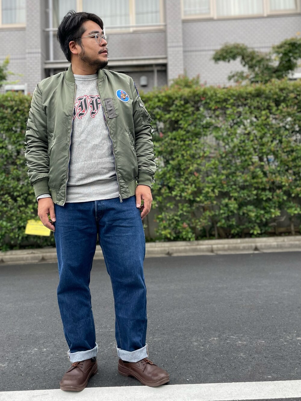 ブルー系のブルゾン、グレー系のスウェット、ブルー系のデニムパンツを着用したメンズの秋コーディネートの2枚目の写真
