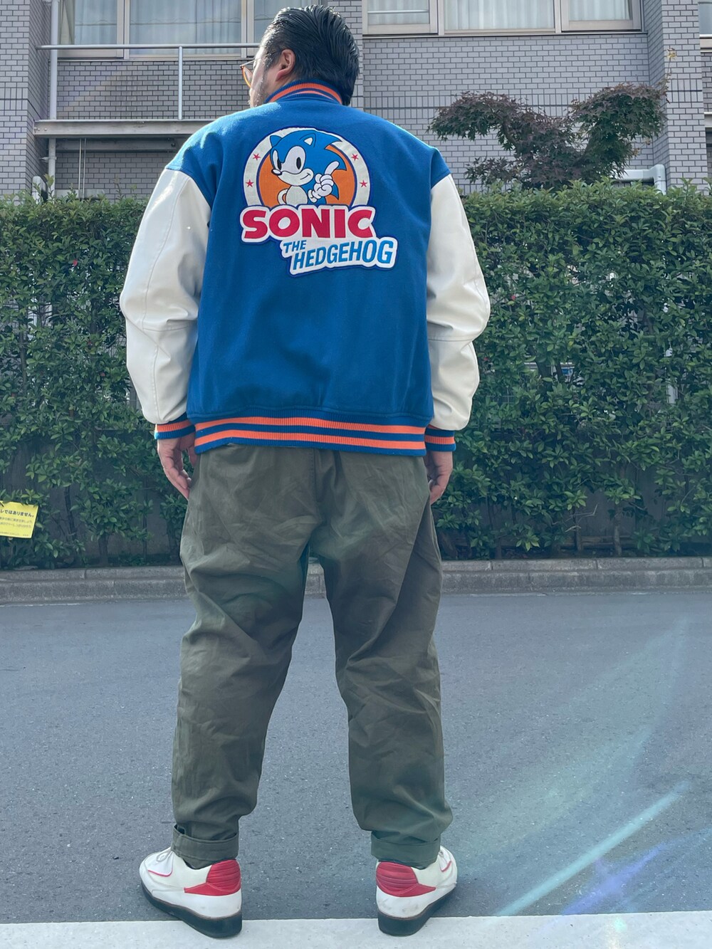 グリーン系のデニムパンツ、ホワイト系のシューズ、グレー系のTシャツ/カットソーを着用したメンズの秋コーディネートの2枚目の写真
