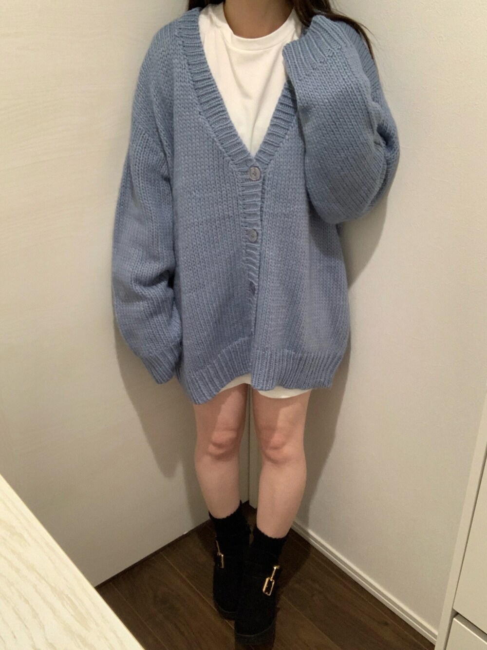 ブルー系のカーディガン/ボレロ、ホワイト系のニット/セーター、ブラック系のブーツを着用したレディースの秋コーディネートの2枚目の写真