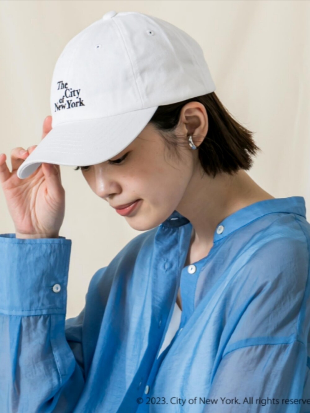 ブルー系のシャツ/ブラウス、ホワイト系のタンクトップ、ホワイト系のキャップを着用したレディースの秋コーディネートの2枚目の写真