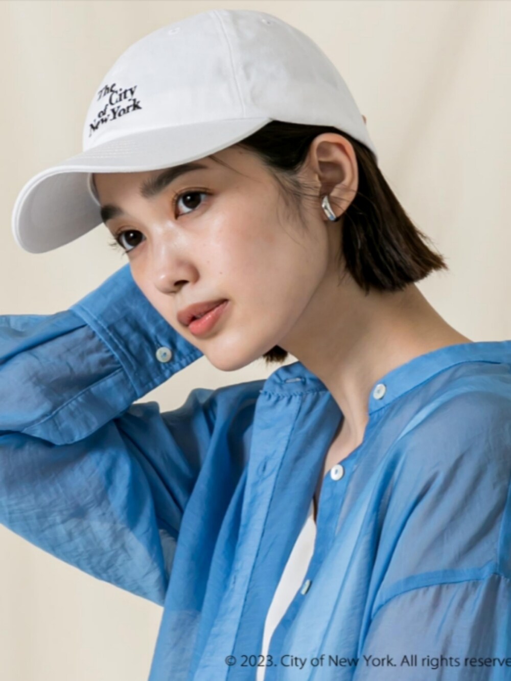 ブルー系のシャツ/ブラウス、ホワイト系のタンクトップ、ホワイト系のキャップを着用したレディースの秋コーディネートの3枚目の写真