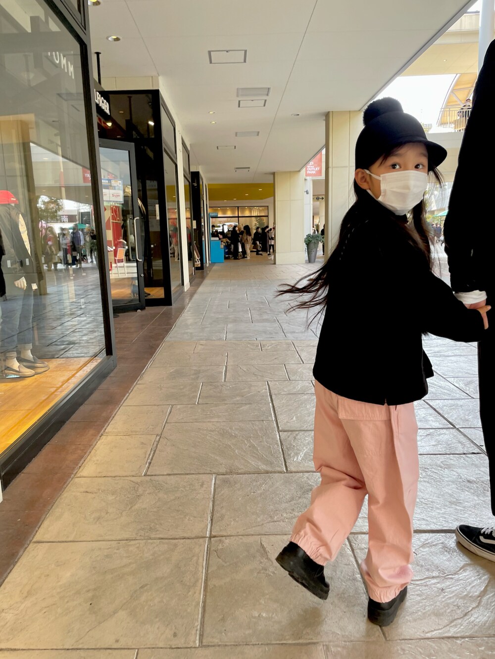 ピンク系のカーゴパンツ、ブラック系のカーディガン/ボレロ、ブラック系のブーツを着用したキッズの冬コーディネートの3枚目の写真