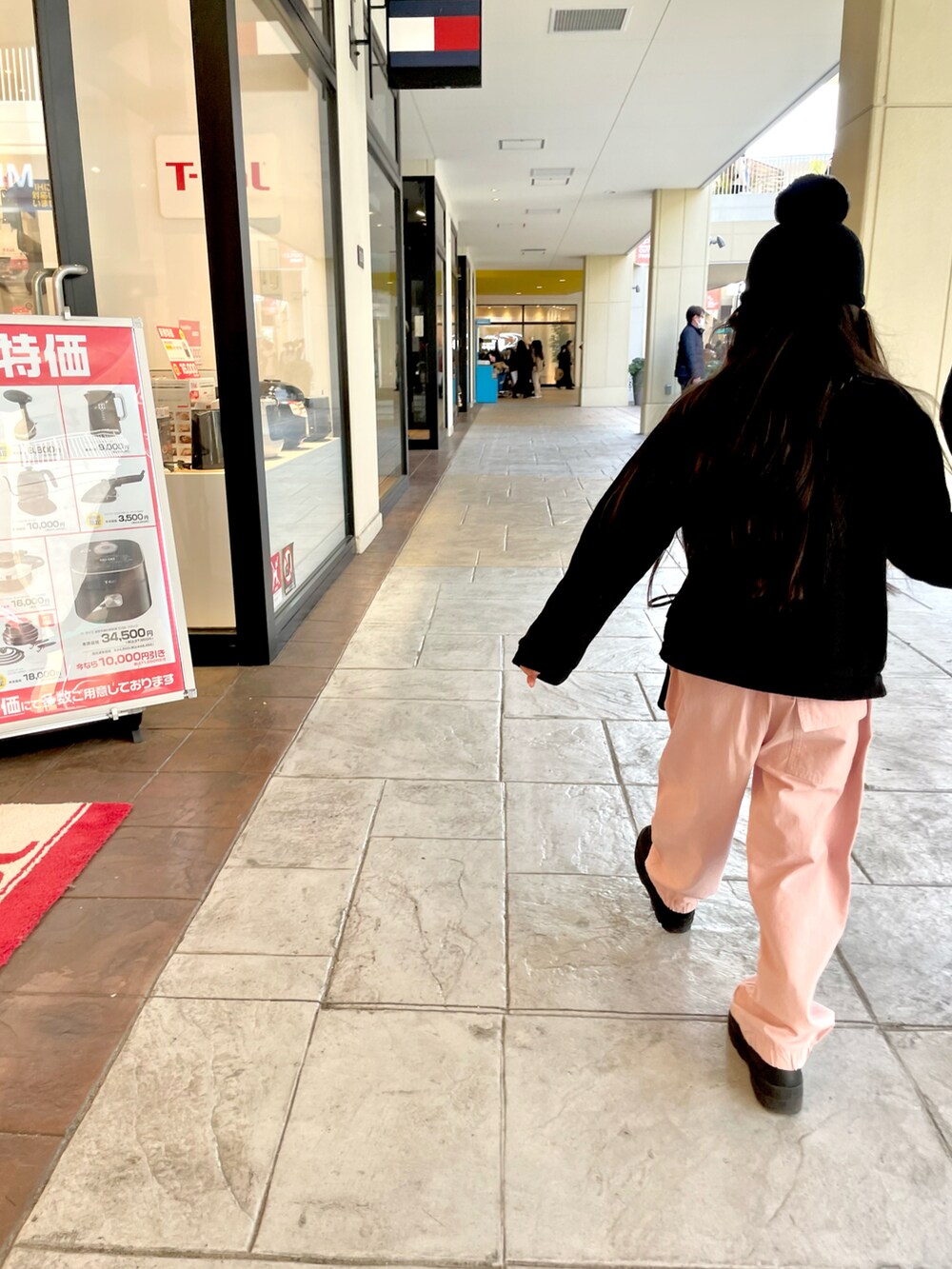 ピンク系のカーゴパンツ、ブラック系のカーディガン/ボレロ、ブラック系のブーツを着用したキッズの冬コーディネートの2枚目の写真