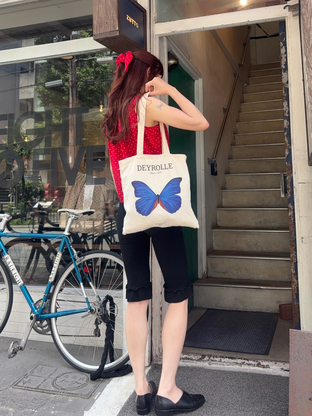 レッド系のシャツ/ブラウス、ブラック系のその他パンツ、ブラック系のスリッポンを着用したレディースの夏コーディネートの3枚目の写真