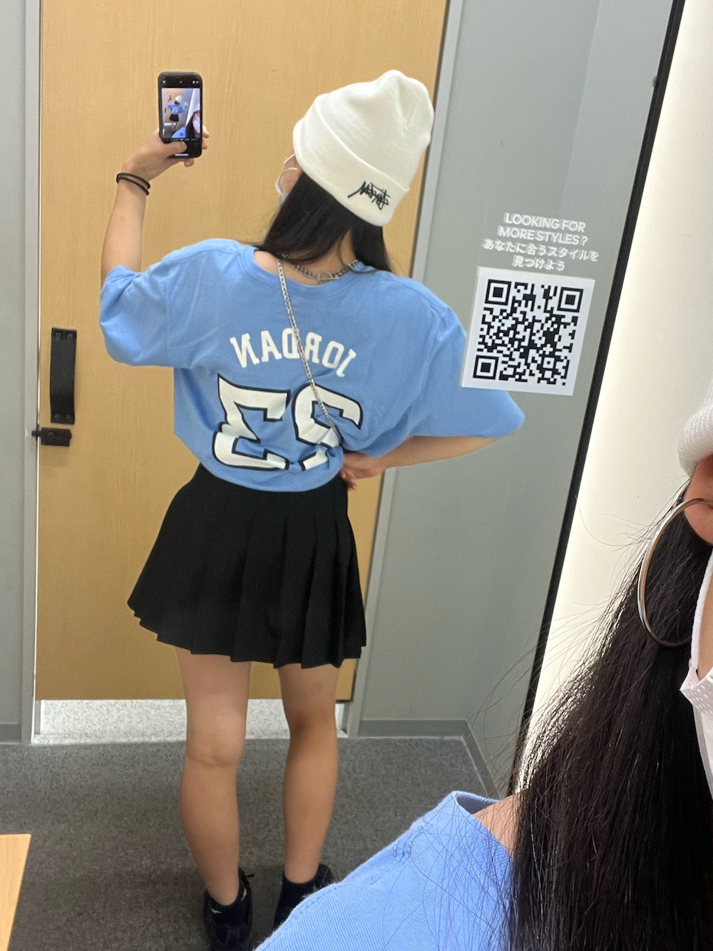 ブルー系のTシャツ/カットソー、ブラック系のスカート、ブラック系のショルダーバッグを着用したレディースの秋コーディネートの2枚目の写真