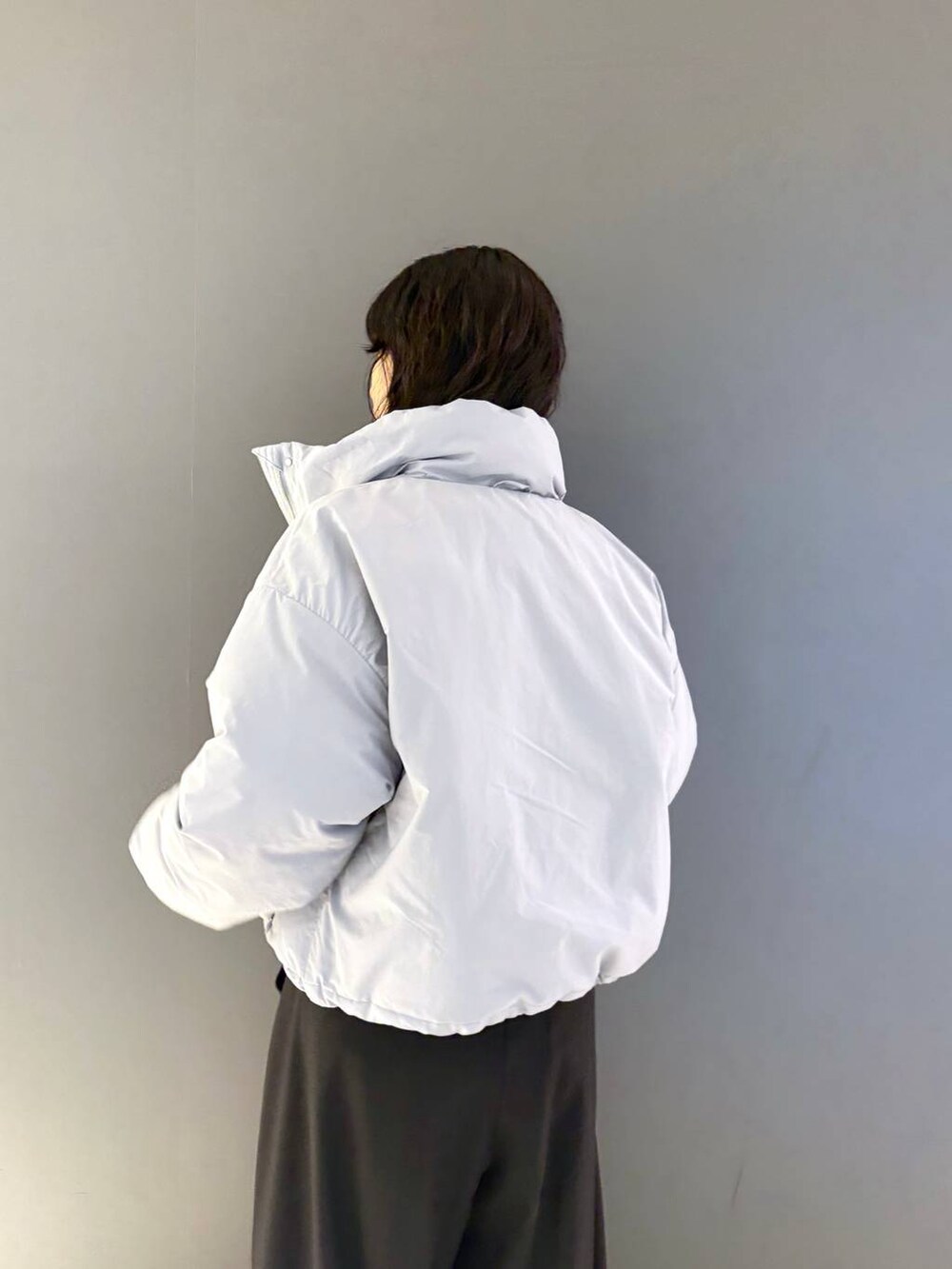 ブラウン系のニット/セーター、ブラック系のスラックス、ブルー系のブルゾンを着用したレディースの冬コーディネートの4枚目の写真