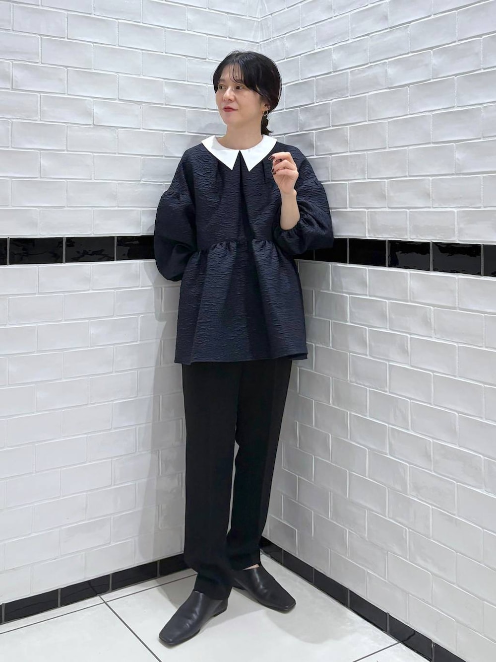 ブルー系のスーツセットを着用したレディースの冬コーディネートの2枚目の写真